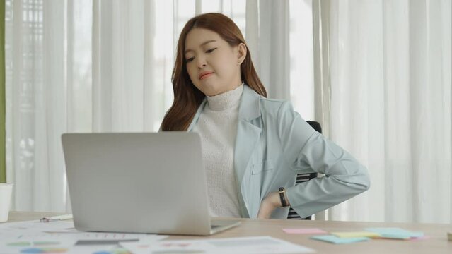 The office syndrome can be caused by sitting in front of a laptop for several hours, concept business asian woman.
