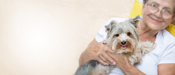 Banner of happy senior elderly woman (over age of 50) hugging lovely Yorkshire terrier dog with...