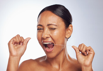 Dental flossing, portrait or mature woman cleaning teeth for beauty or wellness in studio on white...
