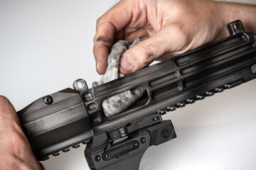 Man`s hands holding rifle parts details and cleaning the gun - obrazy, fototapety, plakaty