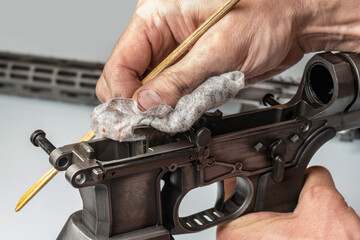 Man`s hands holding rifle parts details and cleaning the gun