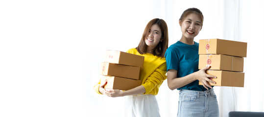 Young woman and her friend prepare boxes for delivery and start a small home business.
