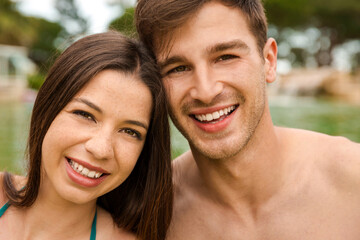 Fototapeta premium Portrait of a young couple embraced inside the pool