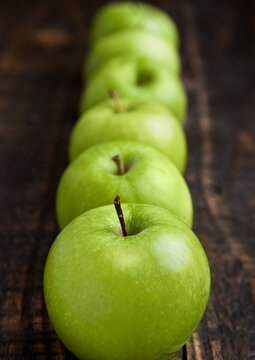 Green organic healthy apples on wooden board. Healthy food