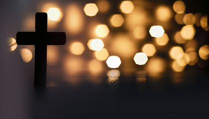 Silhouette of christian cross, lights, bokeh on black background. Copy space.