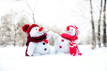 Couple of snowmen taking hand of each other