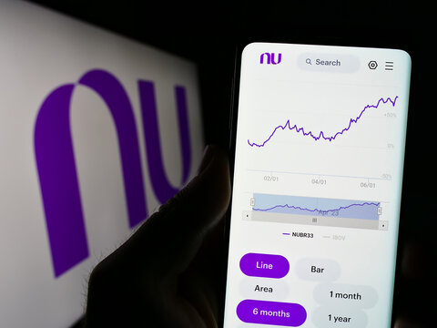 Stuttgart, Germany - 06-30-2023: Person holding smartphone with website of Brazilian company Nu Pagamentos SA (Nubank) on screen with logo. Focus on center of phone display.