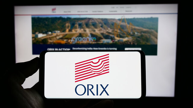 Stuttgart, Germany - 07-01-2023: Person holding mobile phone with logo of Japanese financial company ORIX Corporation on screen in front of web page. Focus on phone display.
