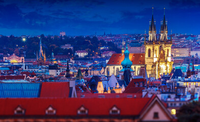 Obraz premium Church of Our Lady Before Tyn among roofs of old houses in Prague city old town, Czech Republic. Evening illumination for buildings and nighttime blue sky after sunset