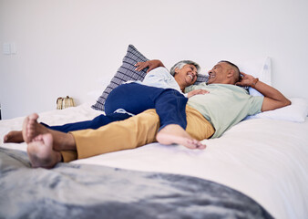 Bed, relax and happy elderly couple laughing, resting and enjoy time together, cuddle and...
