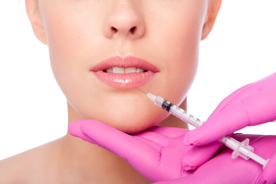 Beautiful plump lips injection with collagen filler Cosmetic spa beauty treatment with pink gloves, on white.