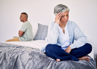 Angry, divorce and a senior couple in the bedroom for a fight, sad and depression in marriage. Stress, mental health and an elderly woman with anxiety about a problem with a man on a bed for conflict