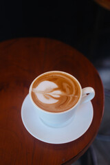 Coffee with a beautiful heart-shaped foam in a white mug. Cappuccino for breakfast