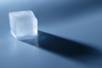 Crystal clear ice cube on light blue background, space for text