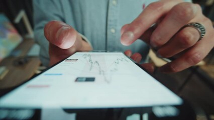 Front shot hands with a mobile phone, checking the market. Scrolling market graph on a touch screen device. Business - Powered by Adobe