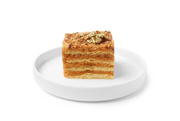 Piece of layered honey cake with walnuts on white background