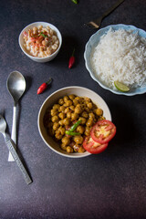 Chickpea masala in a bowl served with rice. Top view, selective focus.