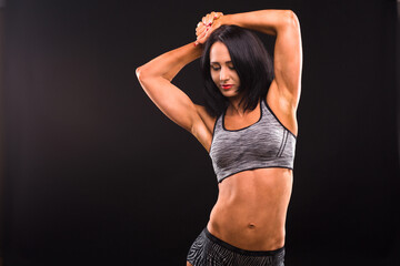 Fototapeta na wymiar Fitness and sports body concept. Picture of brunette woman with red lips training while posing for photographer isolated on black background in studio.