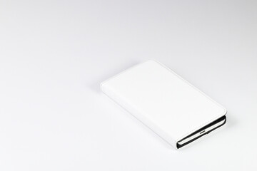 Mobile phone or smart phone in white leather case on white background