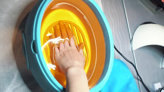 Spa salon. Manicure. Paraffin hand bath. Process paraffin treatment of female hands in beauty salon. Hand care with hot wax, covering with wax, manicure salon. Cosmetic procedures for skin. 