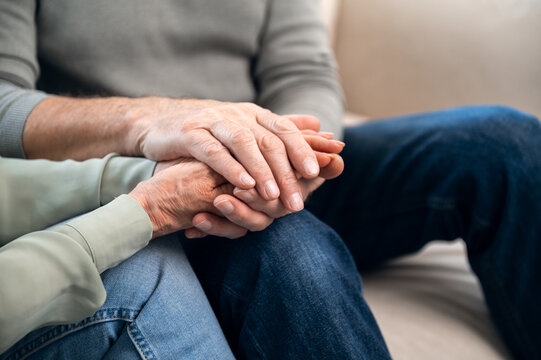 Close up view of mature couple support each other and holding hands