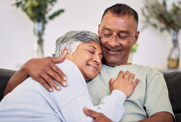 Fototapeta premium Retirement, love and care with mature couple on sofa to relax in family home for bond. Marriage, smile and senior man or woman in living room for rest or calm with happiness for relationship together