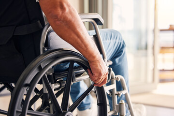 Man, hands and wheelchair for support, hope or travel in healthcare or medicare at home. Closeup of male or person with a disability moving on chair for mobility, surgery or wellness in the house - obrazy, fototapety, plakaty
