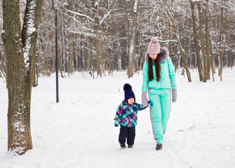 Fototapeta na wymiar Little girl and her mom having fun on a winter day.