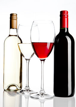 Bottles and glass of red and white wine reflection on white background