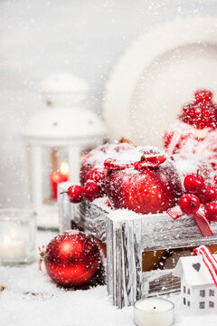 Holiday Christmas composition with red apples, balls, cinnamon, snow and candles
