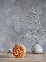 Composition of Mid-autumn festival. Front view moon cake, in the background vase with bouquets of dried flowers. Copy space.