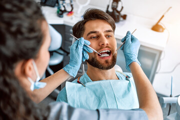 A visit to the dentist. Close-up portrait of a patient with teeth with braces. Medicine, dentistry.