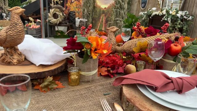 On table plates on wooden stands next to forks knives and glasses Dry heads of red corn red napkins in middle everything is ready for dinner on Halloween autumn October evening Canada