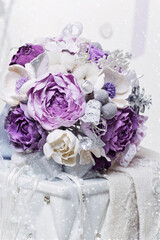 Beautiful hand made art clay bridal bouquet with purple and silver flowers lying on white side table. Copy space.