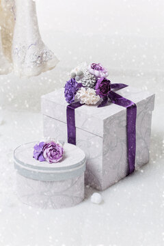 Set of beautiful handmade wedding present boxes ornated with silver and purple flowers standing on snow. Copy space.