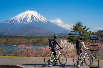 Cycling toulists looking at mt. Fuji during spring season at Lake Shojiko, Yamanashi, Fujikawaguchiko, Japan