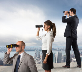 Business people looks at the city from the roof with binoculars