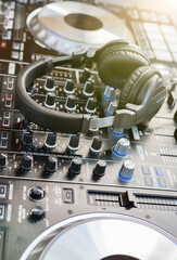 Headphones on dj console deck Big dj headphones to mix music at night club party Professional headset