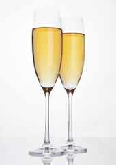 Glasses of sparkling champagne with bubbles on white background