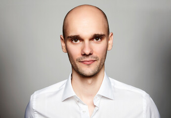 Studio shot of young man looking at the camera. Portrait on gray background.