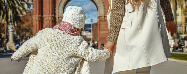 in Barcelona for a perfect winter. Seen from behind modern mother and daughter in Barcelona, Spain...