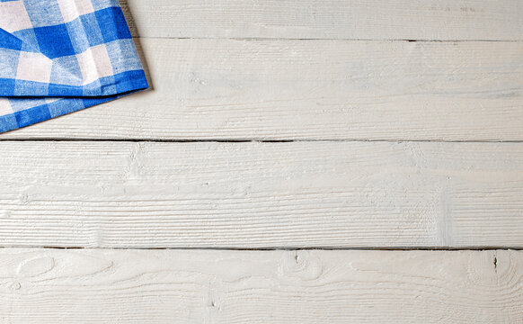 White Wooden Background With A Blue Checkered Napkin In The Corner