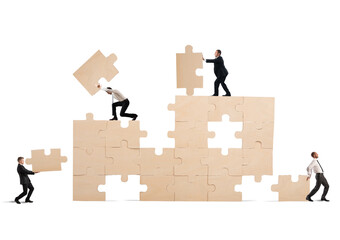 Team of businessmen collaborate and cooperate to build a puzzle