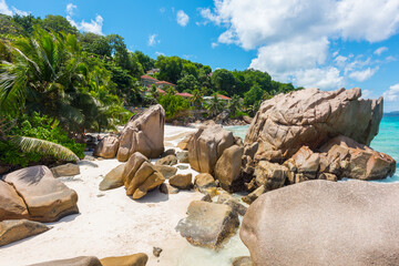 Fototapeta na wymiar Beautifully shaped granite boulders and a perfect white sand at the Anse Patates beach, La Digue island, Seychelles