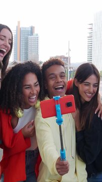 Vertical video. Group of diverse millennials recording a video or taking a photo for social media