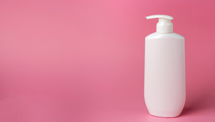 White bottle of moisturizing lotion on pink background with copy space. Minimalism style. Skin care, body treatment, beauty concept