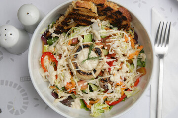 Vegetable salad and toast bread served in a bowl