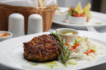 Fried meatballs served with white rice and rosemary on the restaurant table