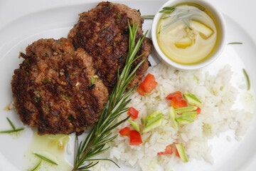 Fried meatballs served with white rice and rosemary on the restaurant table