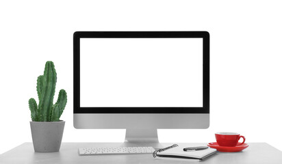 Computer, potted cactus and notebook on table against white background. Stylish workplace